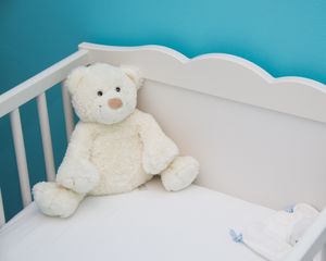 Teddy bear in a cot